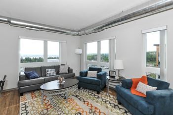 a living room with couches and chairs and a rug at Bluestone Lofts, Duluth